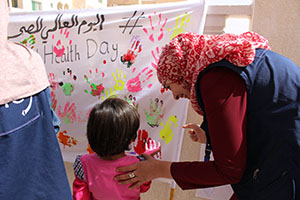 Mother and child leaving their handprints at the Protection Center.