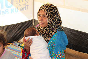 Amira with her youngest child in the tent.