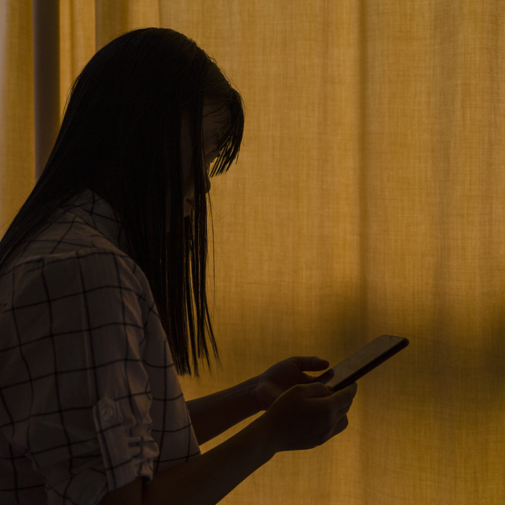 A GBV survivor checks her smartphone in Kuala Lumpur, Malaysia.