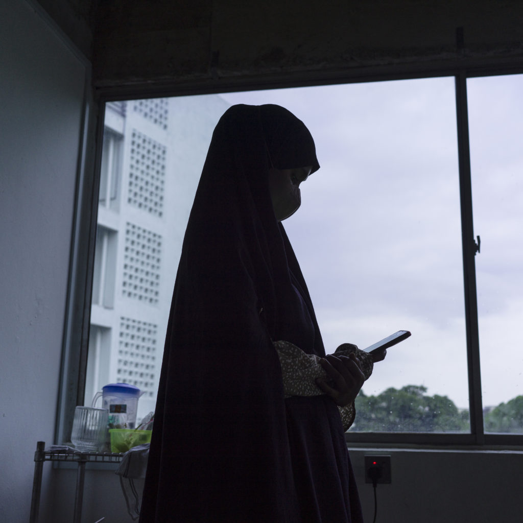 A TFGBV survivor uses her smartphone in Kuala Lumpur, Malaysia 